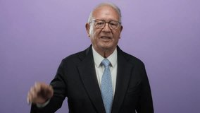 Senior man in business suit waves against an isolated purple background, exuding confidence and professionalism. - Powered by Shutterstock - Get 15% off with code: PIKWIZARD15