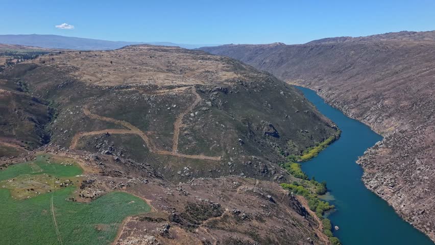 Clutha River winds through rugged hills, peaceful scenic view, Central Otago