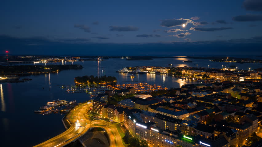 Hyperlapse drone shot over Kruununhaka, toward the moon above the sea of Helsinki