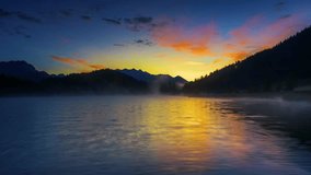 Stunning sunrise over misty mountain lake with golden reflections and colorful sky. Serene forest landscape perfect for nature and travel content. - Powered by Shutterstock - Get 15% off with code: PIKWIZARD15