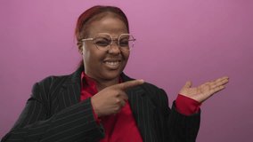 African american woman wearing red blouse and round glasses with smiling face and open hand gestures palm up in studio; joy. - Powered by Shutterstock - Get 15% off with code: PIKWIZARD15