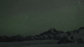 Stunning time lapse of starry night sky over snowy mountain peaks with sea of clouds below, creating a magical winter landscape scene perfect for nature documentaries. - Powered by Shutterstock - Get 15% off with code: PIKWIZARD15