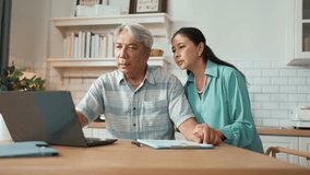 Grandmother comforting and encouraging senior smart manager working and pointing at laptop showing deceasing financial chart. Elder couple helping and talking together while sitting at home. Myrmidon. - Powered by Shutterstock - Get 15% off with code: PIKWIZARD15