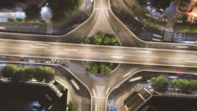 Aerial time-lapse view of busy highway viaduct interchange with traffic light trails at night, showcasing urban transportation infrastructure from above - Powered by Shutterstock - Get 15% off with code: PIKWIZARD15