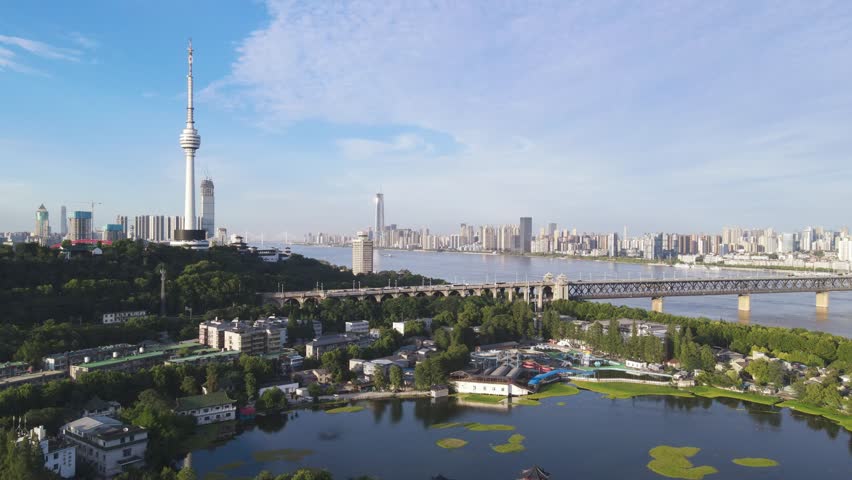 Aerial time lapse view of Wuhan city skyline with Yangtze River bridge, Yellow Crane Tower, and urban development showcasing China