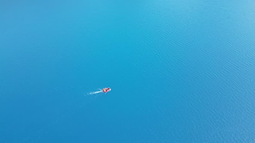 Band E Amir Drone Aerial, Afghanistan. Pristine turquoise lake oasis, lush trees in desert landscape, Boat of tourists