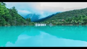 Stunning turquoise lake reflection in Lijiang valley, Yunnan China with misty mountains and traditional architecture creating a serene natural landscape perfect for travel content. - Powered by Shutterstock - Get 15% off with code: PIKWIZARD15
