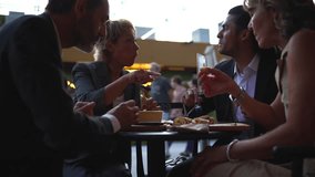Group of four diverse coworkers enjoying appetizers and engaging in conversation during a business lunch meeting at an elegant outdoor cafe, fostering professional relationships - Powered by Shutterstock - Get 15% off with code: PIKWIZARD15