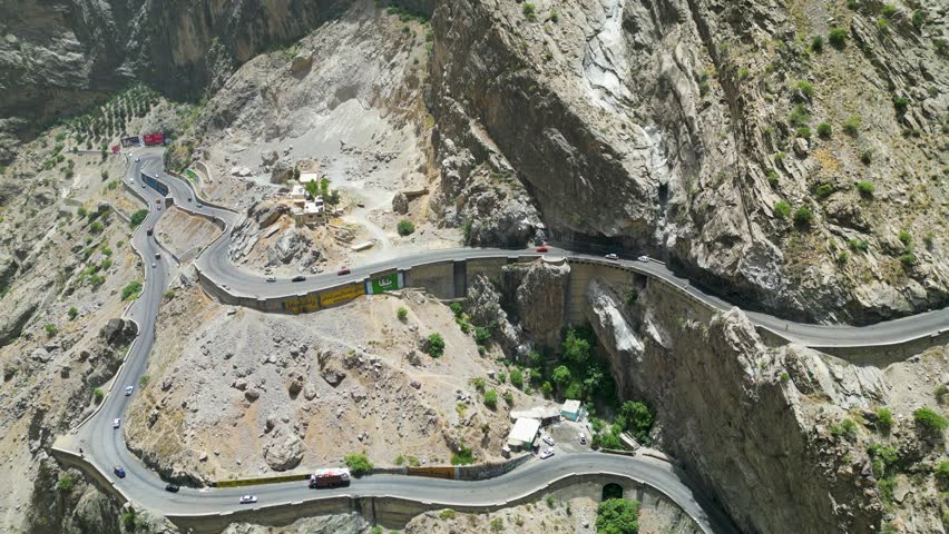 Winding mountain roads in arid Hindu Kush mountains bordering Pakistan. Dangerous traffic