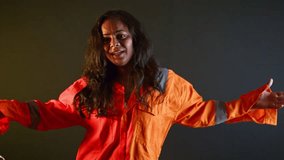 Cheerful detainee twirls holds shackled in hands, Joyful lady prisoner with cuffs dance freely, Female Thief Grooves inside Custody, Happy criminal rocks carries freedom on mind, Felon wears jumpsuit - Powered by Shutterstock - Get 15% off with code: PIKWIZARD15