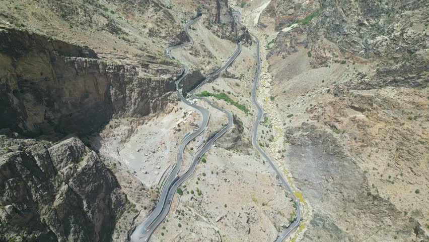 Winding mountain roads in arid Hindu Kush mountains bordering Pakistan, drone aerial, Afghanistan, Taliban road