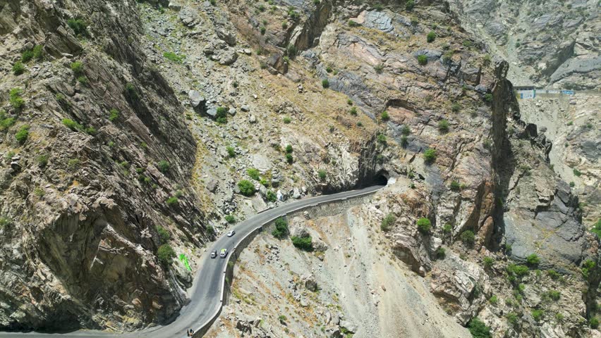 Dangerous Winding mountain roads and tunnel in arid Hindu Kush mountains near Kabul, Afghanistan bordering Pakistan. Drone Aerial