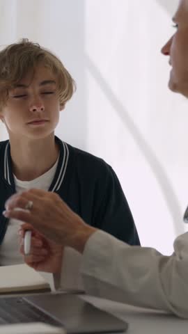 Young man in a medical consultation with a female doctor, carefully paying attention as she provides guidance and diagnosis on his health condition and treatment options in her office