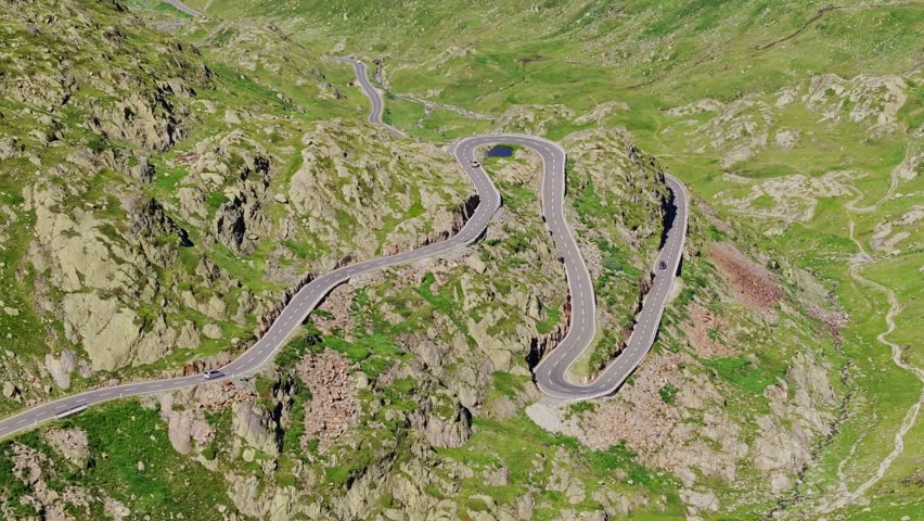 Beautiful aerial shot of curved mountain highway through the green Alps region