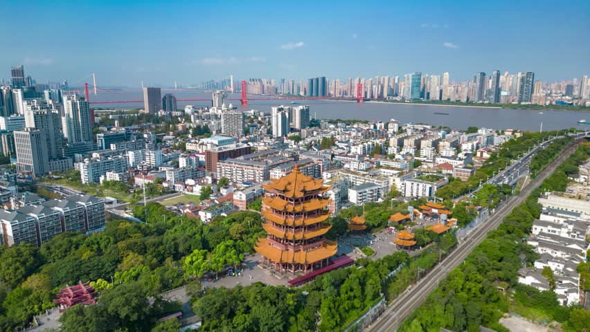 Aerial time lapse view of Yellow Crane Tower (Huanghe Lou) in Wuhan, Hubei Province, China with modern cityscape and Yangtze River in background