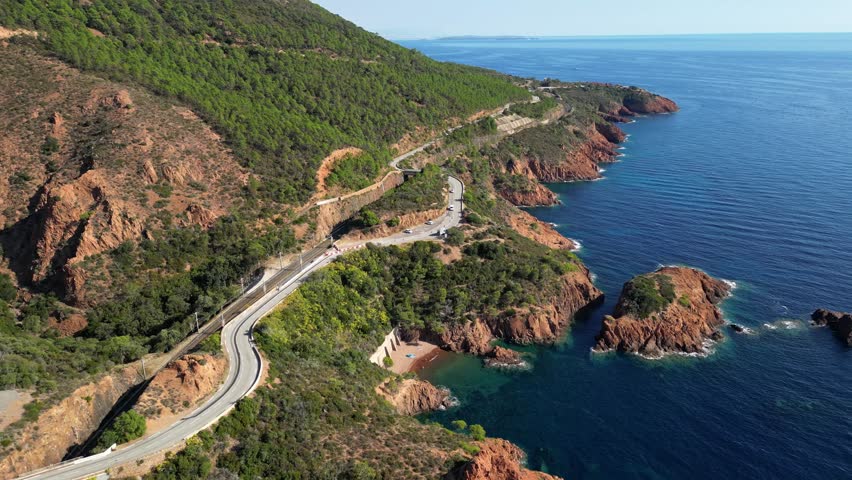 Aerial view of Esterel Mountains and winding coastal road above the blue Mediterranean Sea, French Riviera, France