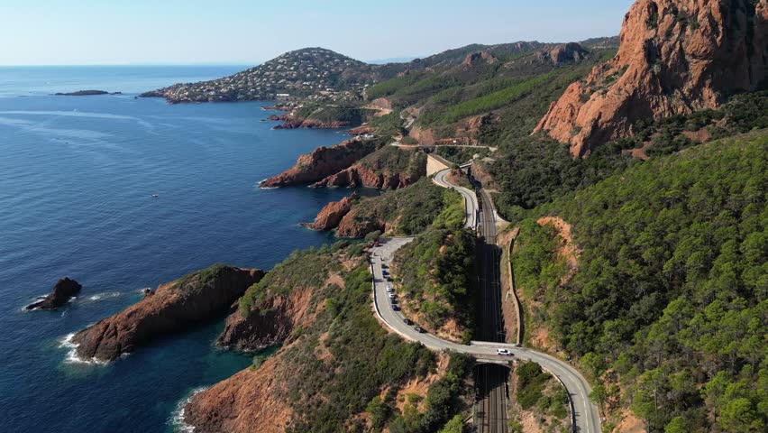 Aerial view of Esterel Mountains and winding coastal road above the blue Mediterranean Sea, French Riviera, France