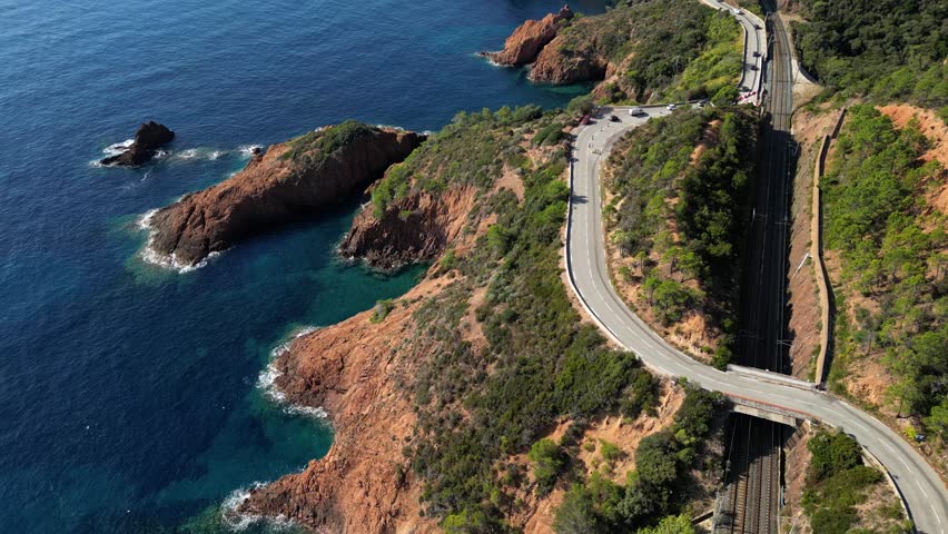 Aerial view of Esterel Mountains and winding coastal road above the blue Mediterranean Sea, French Riviera, France