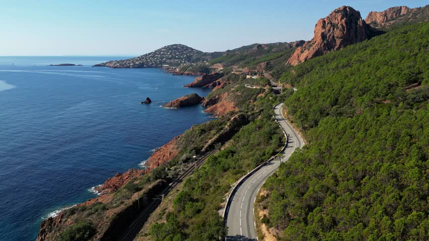 Aerial view of Esterel Mountains and winding coastal road above the blue Mediterranean Sea, French Riviera, France