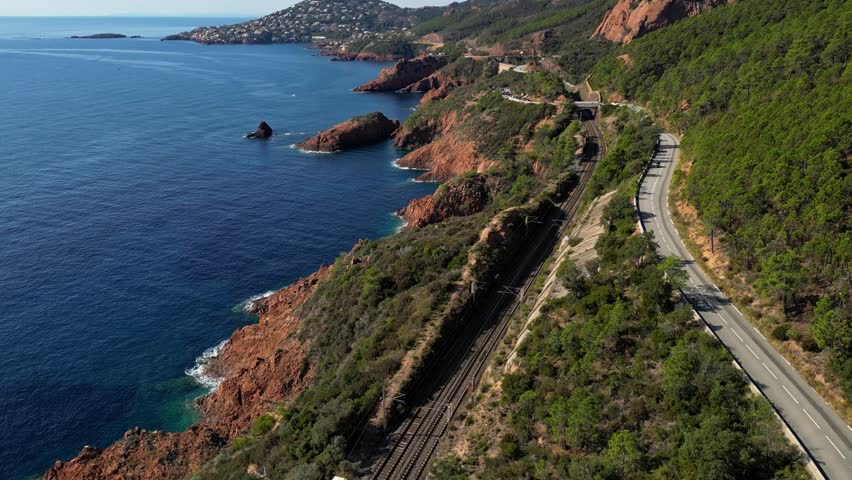 Aerial view of Esterel Mountains and winding coastal road above the blue Mediterranean Sea, French Riviera, France