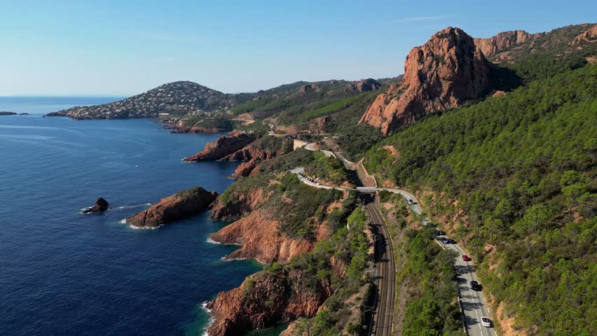 Aerial view of Esterel Mountains and winding coastal road above the blue Mediterranean Sea, French Riviera, France
