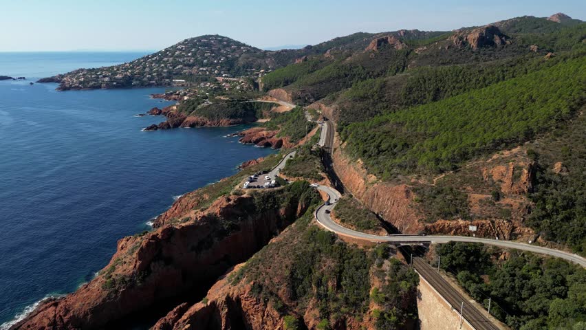 Aerial view of Esterel Mountains and winding coastal road above the blue Mediterranean Sea, French Riviera, France