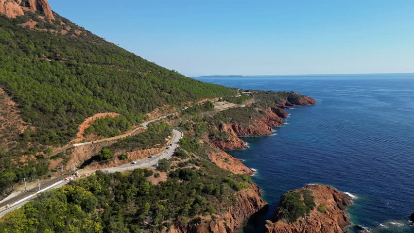 Aerial view of Esterel Mountains and winding coastal road above the blue Mediterranean Sea, French Riviera, France