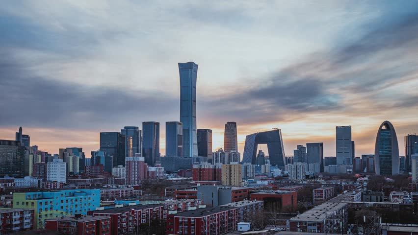 Beijing CBD skyline at sunset with modern skyscrapers and residential buildings under dramatic cloudy sky during golden hour time lapse view