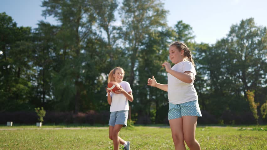 American children playing ball. American football sports concept. American football with children playing in park. American football player and his lifestyle children playing football in park.
