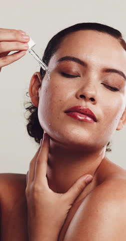 Woman, dropper and serum for skincare in studio with beauty, hydration oil and collagen treatment. Person, cosmetics and hyaluronic acid for smooth texture, vitamin c and wellness on white background