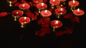 Red candles burning with scattered rose petals creating romantic ambiance on dark background, perfect for Valentine's Day, anniversary or intimate dinner setting. - Powered by Shutterstock - Get 15% off with code: PIKWIZARD15