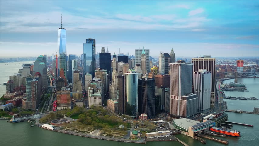 Aerial View Of A Modern Metropolitan Skyline With Skyscrapers, Glass Towers, And Waterfront Architecture Under A Clear Blue Sky Representing Business And Progress. Manhattan, New York City.