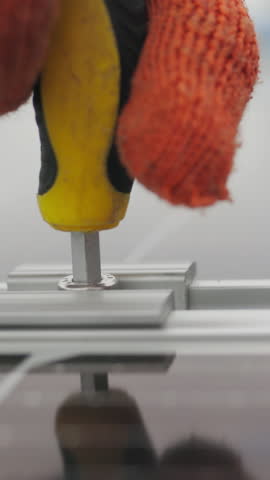 A worker installs a solar panel with a gloved hand, showcasing the process of renewable energy installation.