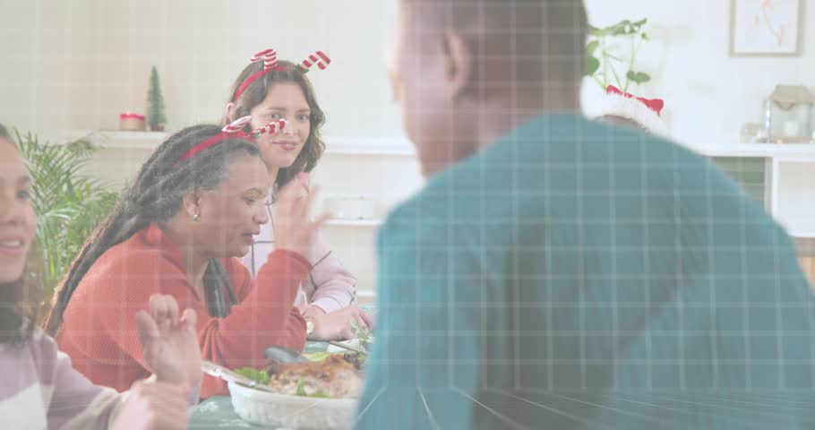 Green cloud grid overlay fading during holiday meal as boy warmly greeting man wearing Santa hat. Family, celebration, festivity, togetherness, warmth, affection, multicultural