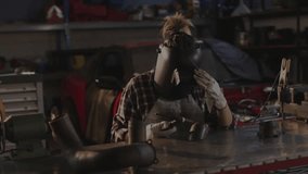 Woman welder lifting helmet visor and inspecting welds with torch under digital overlay. Industrial, craftsmanship, precision, technology, manufacturing, engineering, durability - Powered by Shutterstock - Get 15% off with code: PIKWIZARD15