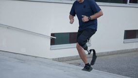 Man with a disability, wearing prosthetic equipment, a running blade, running up the city stairs, close up side view. Leg prosthesis, sport and recreation concept. - Powered by Shutterstock - Get 15% off with code: PIKWIZARD15