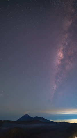 Time lapse The Milky Way spins over Mount Bromo volcanoes. The Milky Way sparkles above the summit of Bromo Volcano and stands perpendicular to the summit of Mount Bromo spewing white smoke