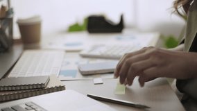 Closeup to hands of Asian businesswoman sitting at her desk and using a pen writing planning to sticky note and putting to calendar for agenda in future in office. Young female worker working at home. - Powered by Shutterstock - Get 15% off with code: PIKWIZARD15