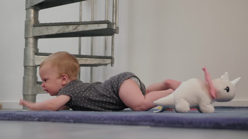 A cheerful baby crawls on a soft carpet, representing the joy of early movements and infants curiosity as they explore their vibrant world