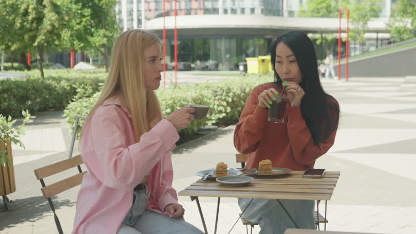 Stylish Women Drinking Coffee And Soda Together At Sunny Outdoor Cafe