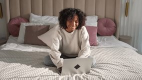African American girl using laptop in bed at home office typing chatting reading writing email. Young black woman having virtual meeting online chat video call conference. Work learning from home - Powered by Shutterstock - Get 15% off with code: PIKWIZARD15