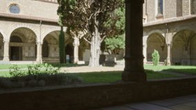 Cloister courtyard defocused soft background with arched colonnade, stone facade and central cypress tree garden; backdrop copyspace backplate. - Powered by Shutterstock - Get 15% off with code: PIKWIZARD15