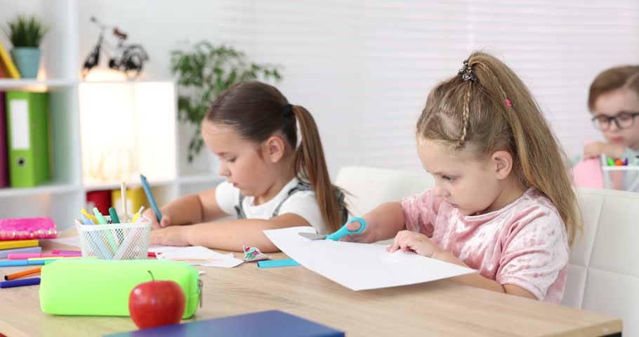 Smiling children at wooden desk during art lesson in elementary school