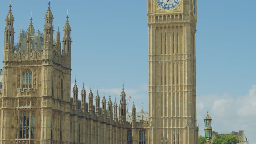 Close up shot of Big Ben and the Palace of Westminster on a clear sunny day. Palace of Westminster and the Elizabeth Tower with the Big Ben clock face under a bright blue sky.