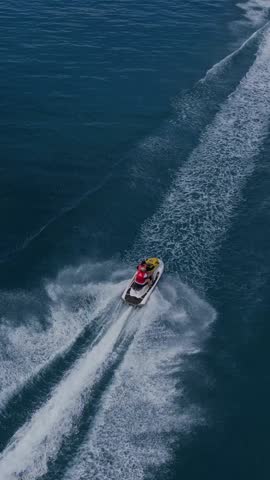 Epic footage of two water scooters racing at crystal clear water of Indian Ocean. Young couple enjoying summer vacation near Thulusdhoo island.Maldives.Vertical video