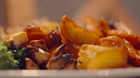 Close Up View of Gravy Being Poured on Roast Sunday Lunch with Crispy Delicious Potatoes with Carrots and Broccoli. Classic British Cuisine Food. - Powered by Shutterstock - Get 15% off with code: PIKWIZARD15