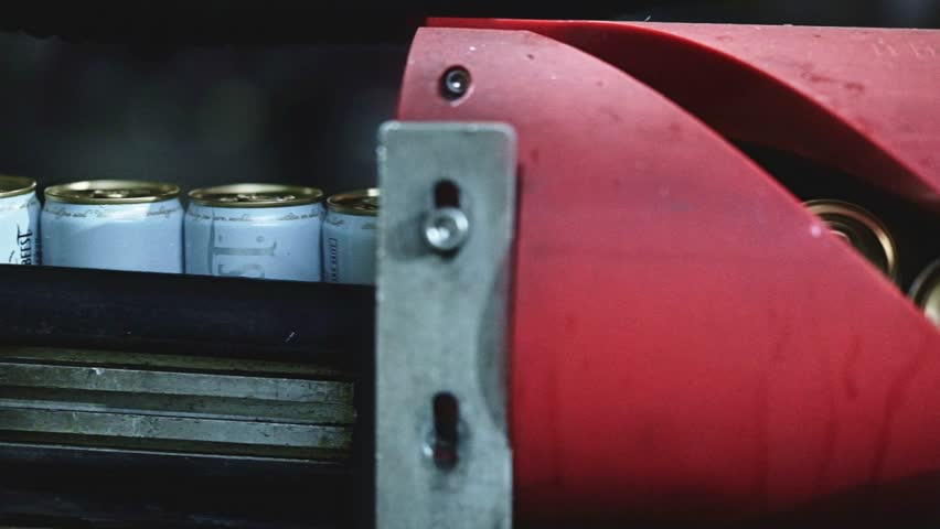 Beverage cans moving through a machine that flips the cans