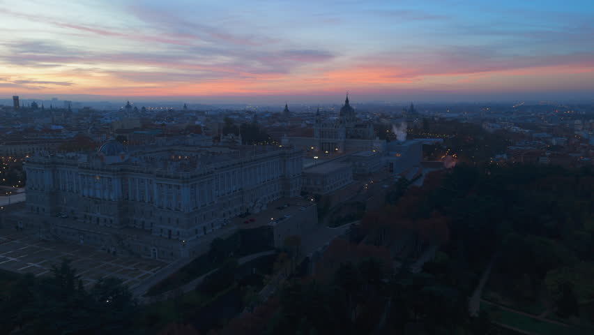 Aerial view captures the Royal Palace of Madrid at sunset, highlighting its majestic architecture and the citys rich history and vibrant culture that attract tourists globally. Spain