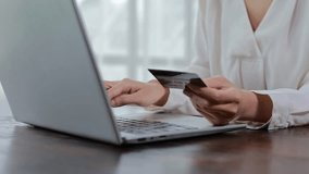 Professional woman securely processing online payment, typing credit card details on laptop keyboard while working at home office desk, focusing on digital transaction process - Powered by Shutterstock - Get 15% off with code: PIKWIZARD15