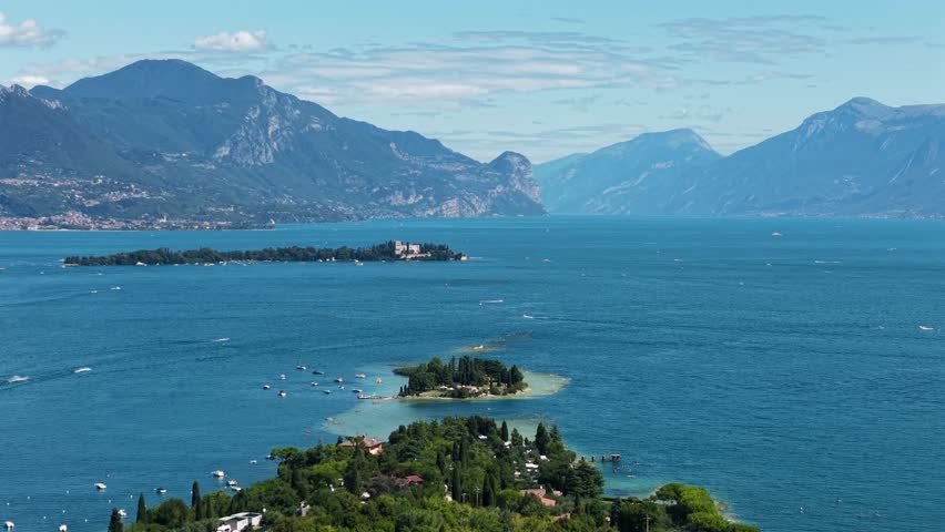 Scenic aerial view of Isola di San Biagio, a small island on Lake Garda, Italy, filmed by cinematic drone in summer.